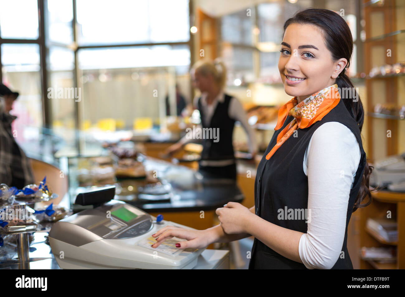 Shopkeeper and saleswoman at cash register or checkout counter Stock Photo