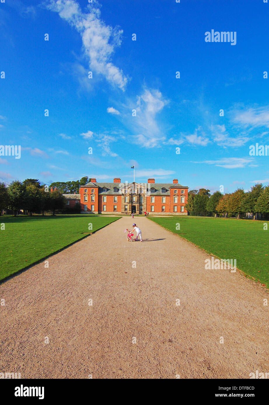 Little girl and her bike on the long road to a stately home Stock Photo