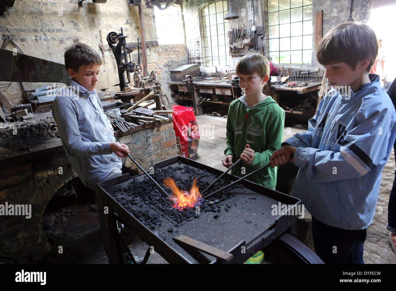 Pomerania, Germany, Boys heat iron bars in the fire Stock Photo
