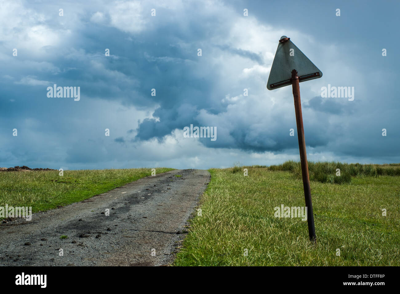 Broken Road Sign By A Country Lane Under A Stormy Sky Stock Photo
