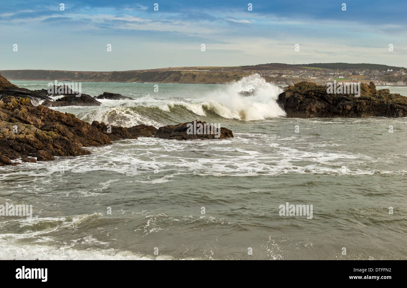 CULLEN TOWN MORAYSHIRE THE WINTER SEA WITH HUGE WAVES BREAKING OVER ROCKS IN THE BAY Stock Photo