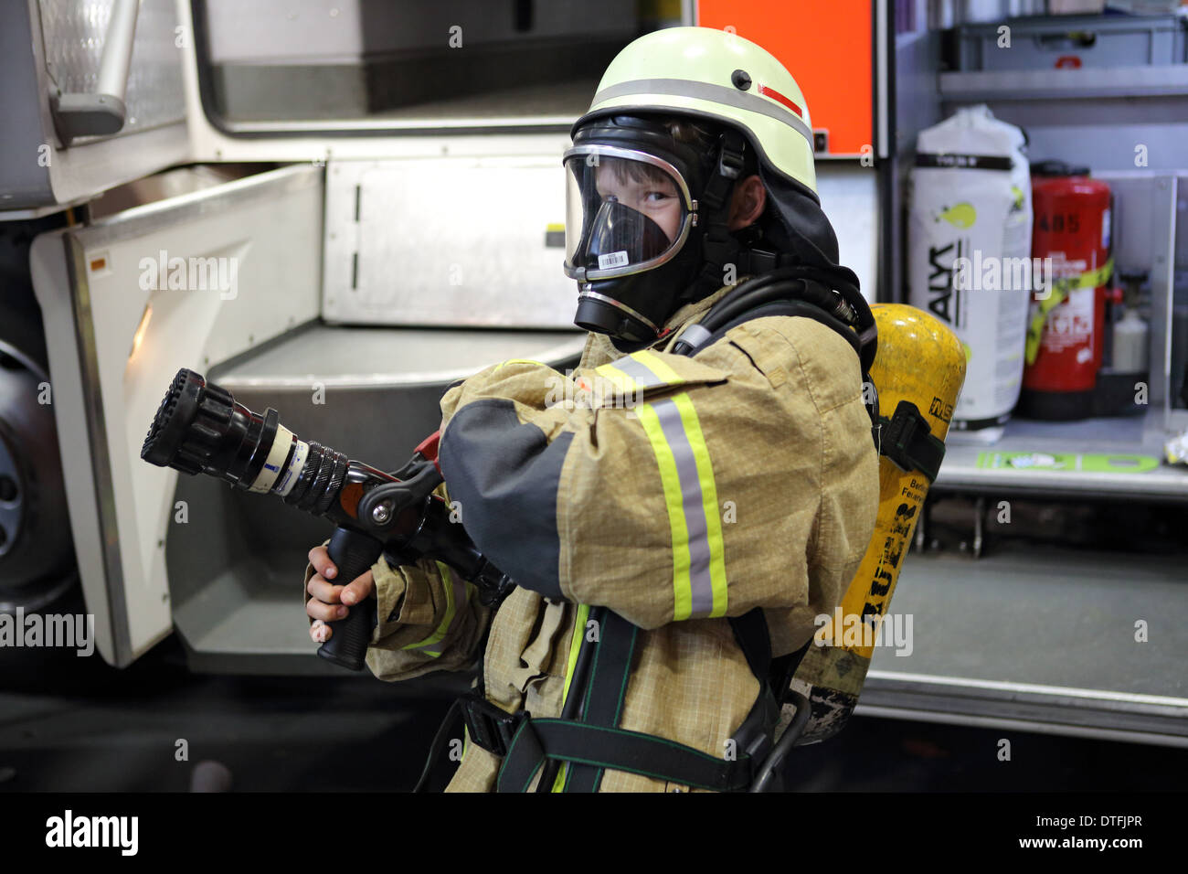 Berlin, Germany, boy carries on the Youth Fair YOU a protective suit of fire- Stock Photo