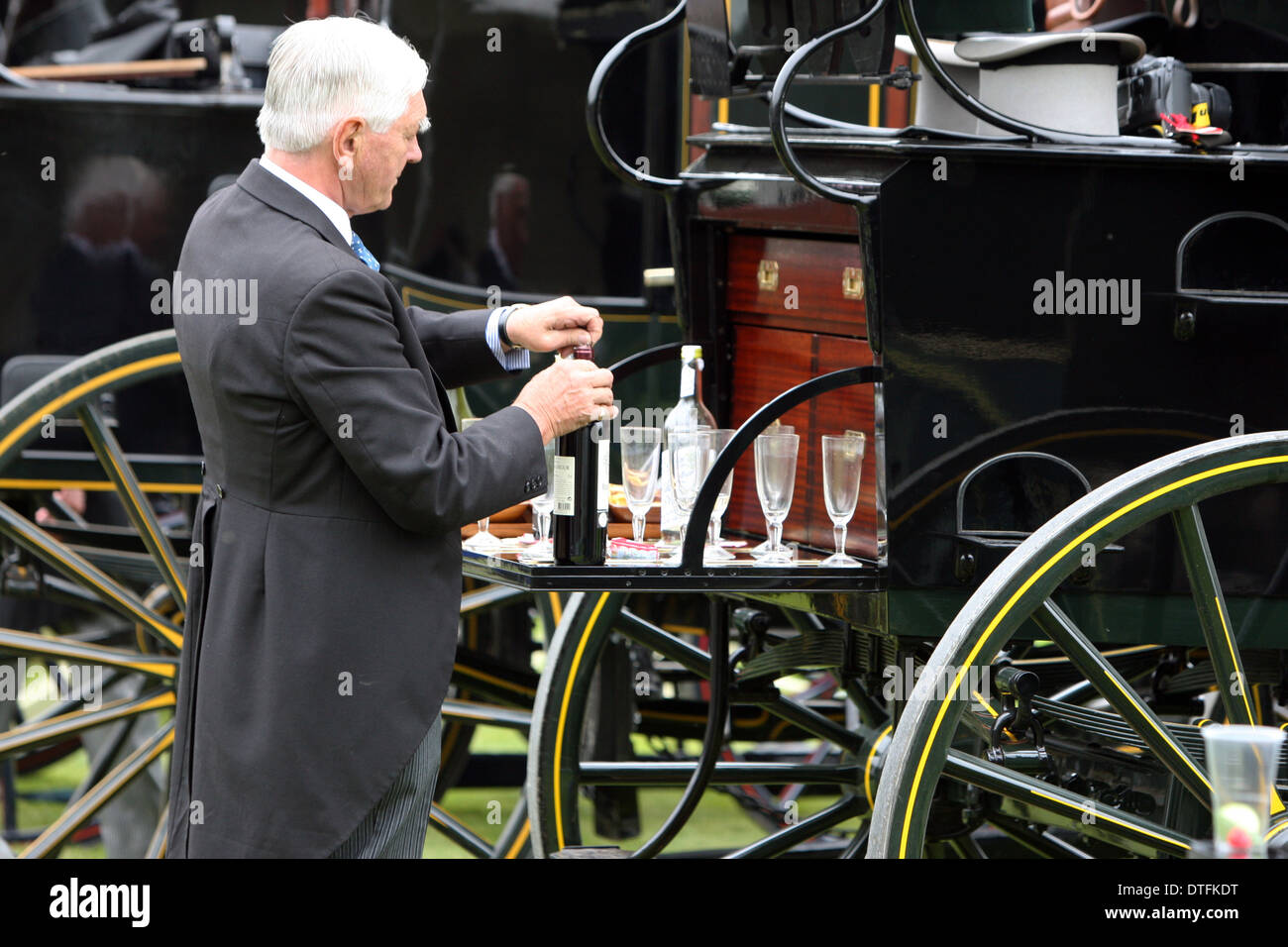Ascot, United Kingdom, elegantly dressed man gives to a carriage a sparkling wine Stock Photo