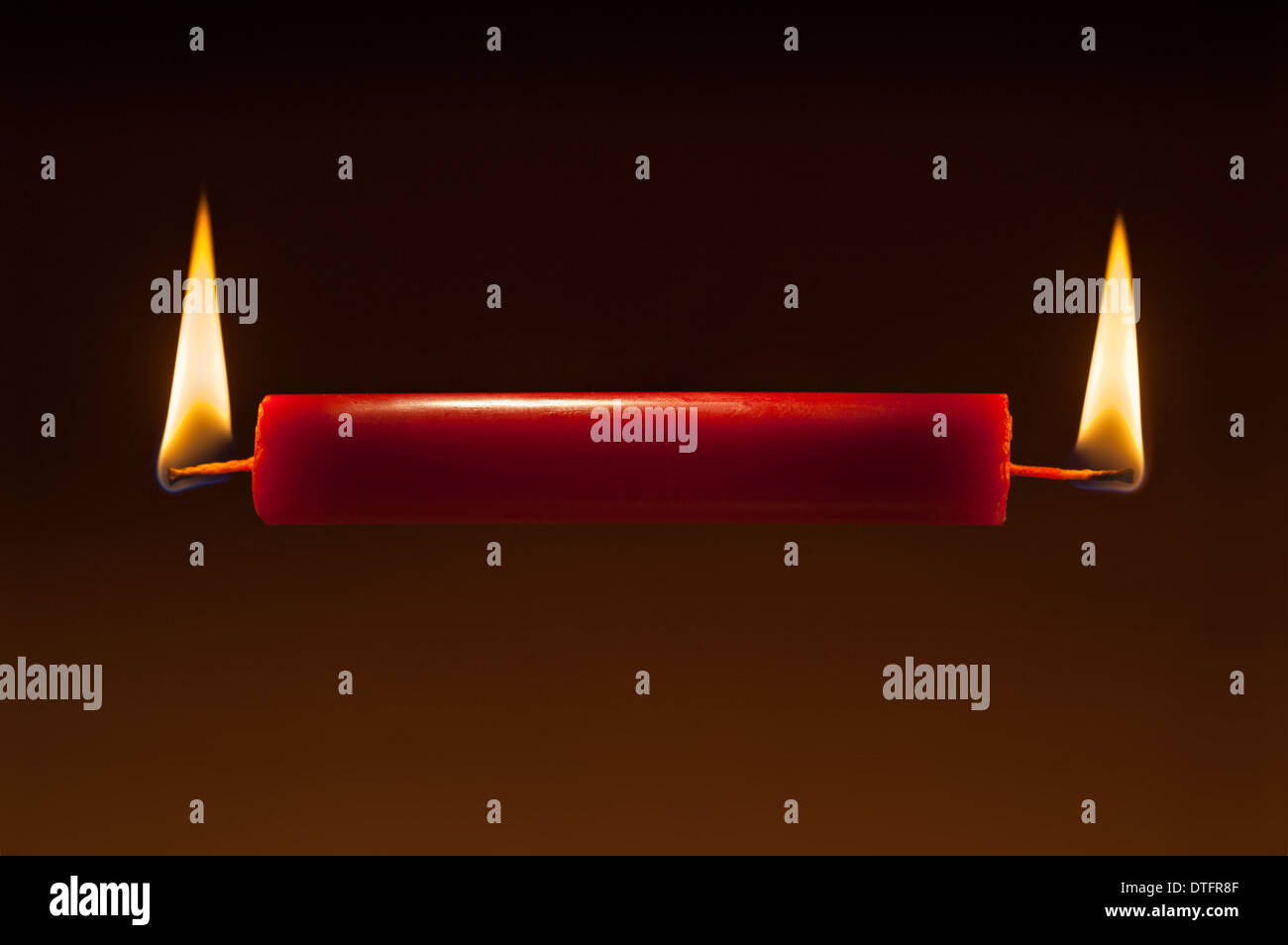 red candle burning at both ends, concept, axiom, overworked Stock Photo