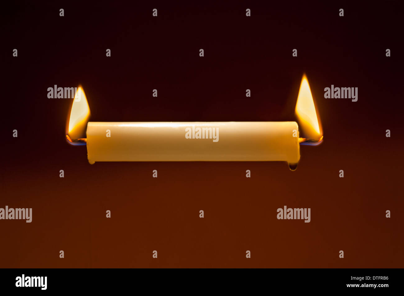 white candle burning at both ends, concept, axiom, overworked Stock