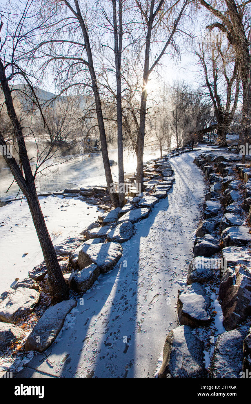 Snow and ice on a footpath along the Arkansas RIver which runs through the downtown historic district of Salida, Colorado, USA Stock Photo