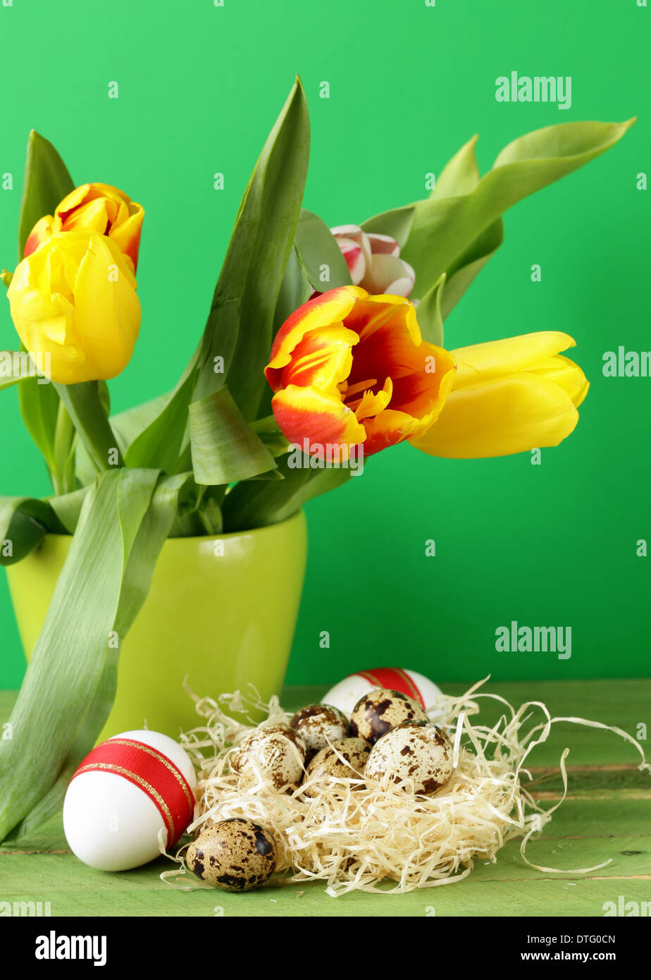 Easter still life with spring flowers tulips and quail eggs on a wooden ...