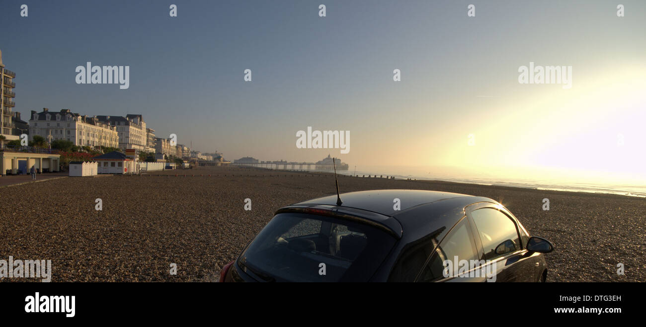 Car on beach at Eastbourne, Sussex, England with Eastbourne pier in backgroundstructures Stock Photo