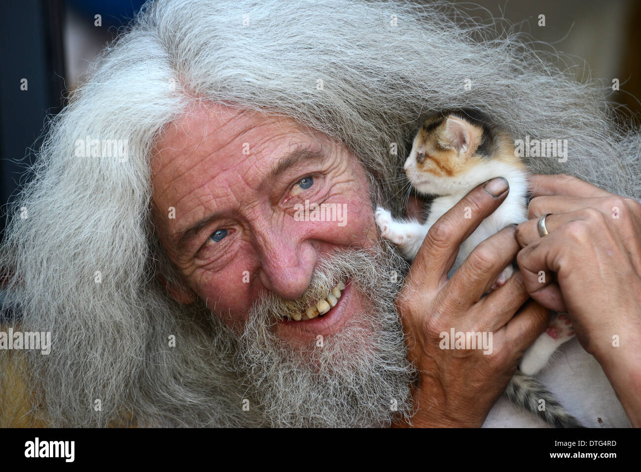 Man with long hair and beard John Julian with one of the kittens he found in his shed. kind animal lovers kitten rescue rescued Britain Uk people male Stock Photo