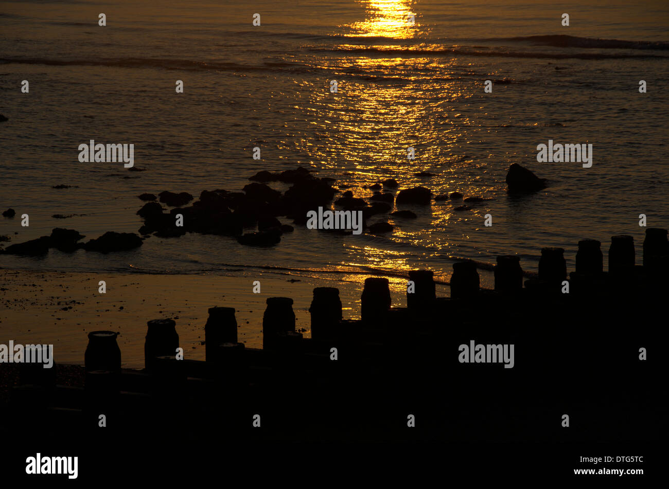 Early morning, Eastbourne in Sussex England as the sun rises over the sea and deserted, beach Stock Photo