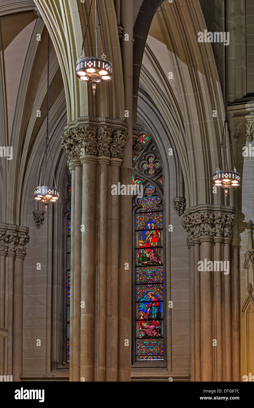 Details of the intricate architectural details and stained glass window at the iconic National Historic Landmark of the Neo-Gothic style architecture of Saint Patrick's Cathedral in New York City. Stock Photo