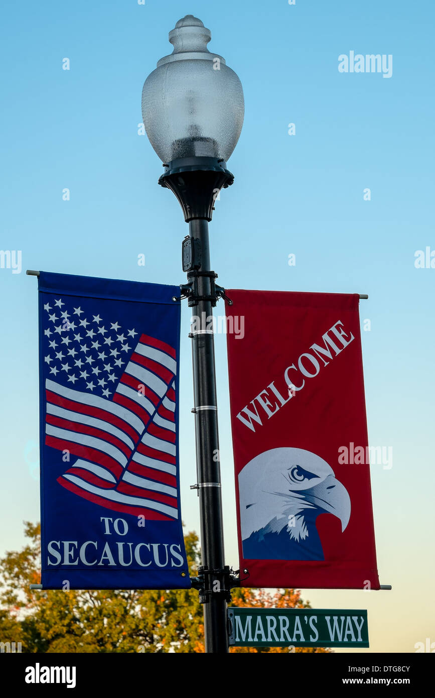 Secaucus replica of an old fashioned lamp post along with red white and blue banners. One banner with the an Eagle's head and the other with the USA flag saying welcome to Secaucus. This is located in Marra's Way in Secaucus, New Jersey. Stock Photo
