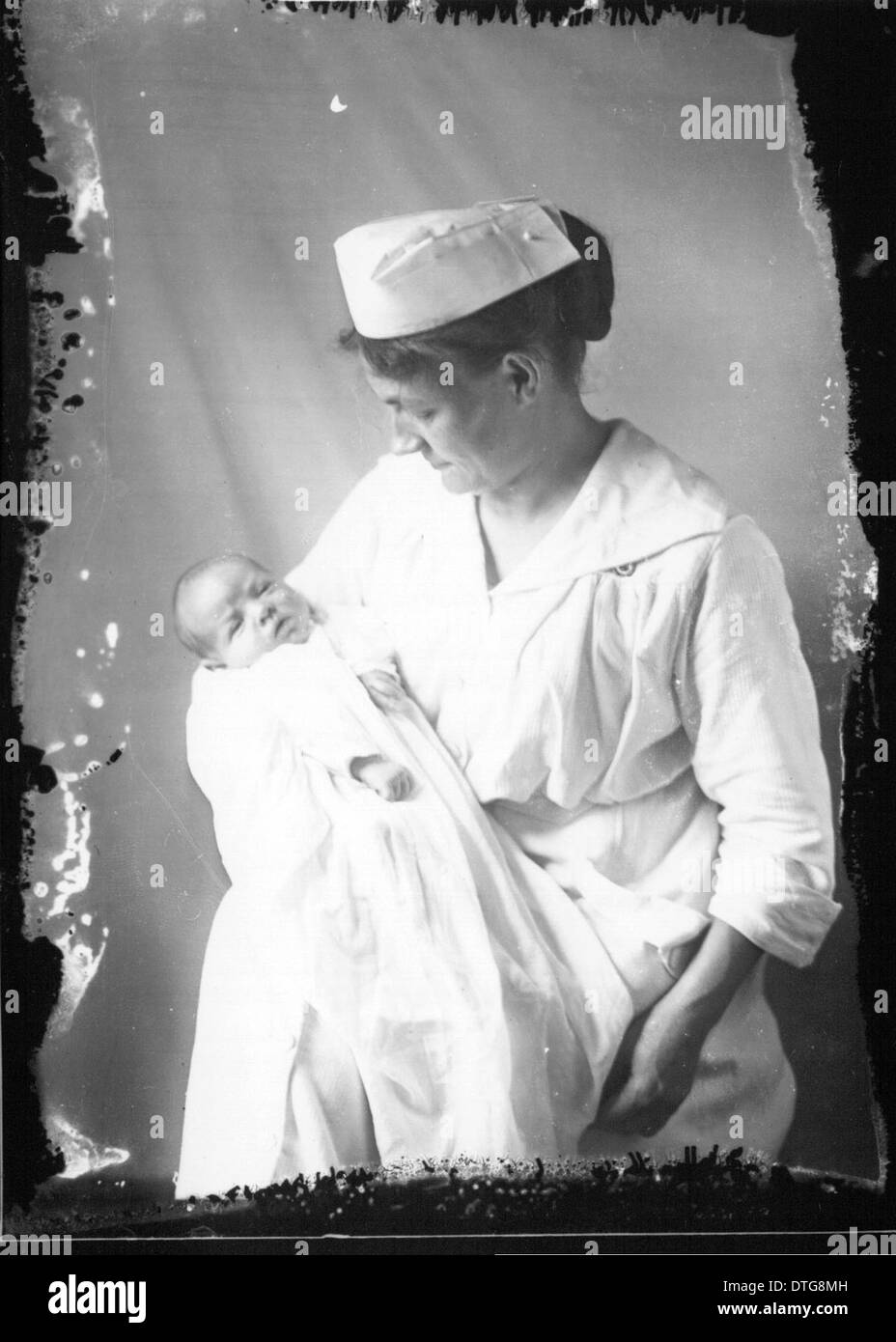 This historical portrait photograph captures a baby with a nurse ...