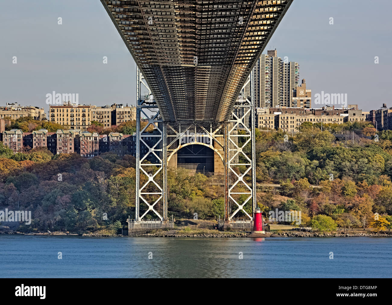 A view from below the George Washington Bridge (GW Bridge) also referred to as to the Big Gray Bridge to the New York City skyline and to Jeffrey's Hook Lighthouse also referred to as the Little Red Lighthouse. This image is the color version. Stock Photo