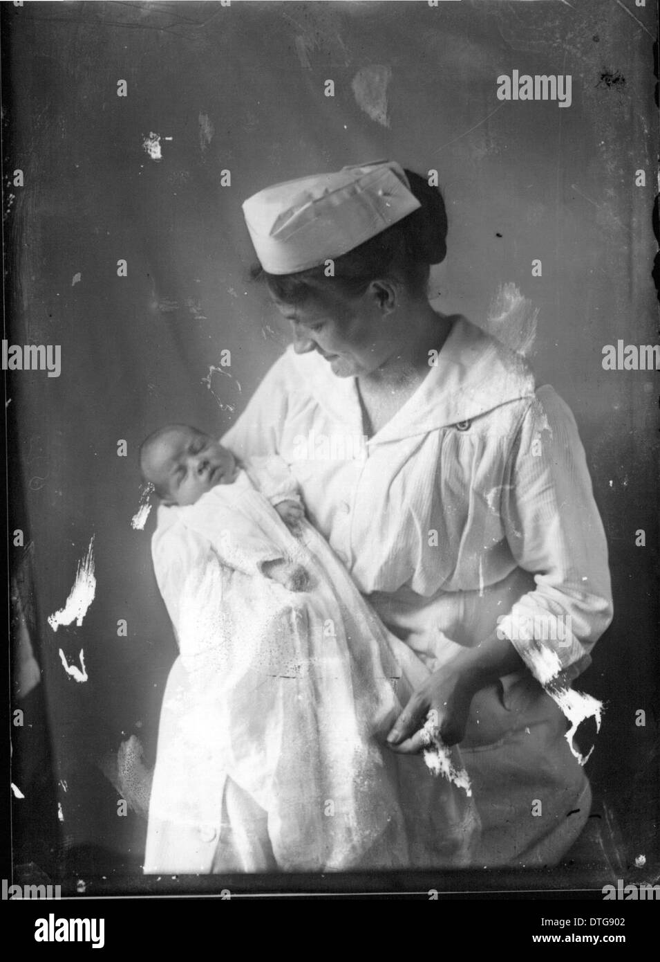 This portrait photograph captures a baby with its nurse, offering a ...