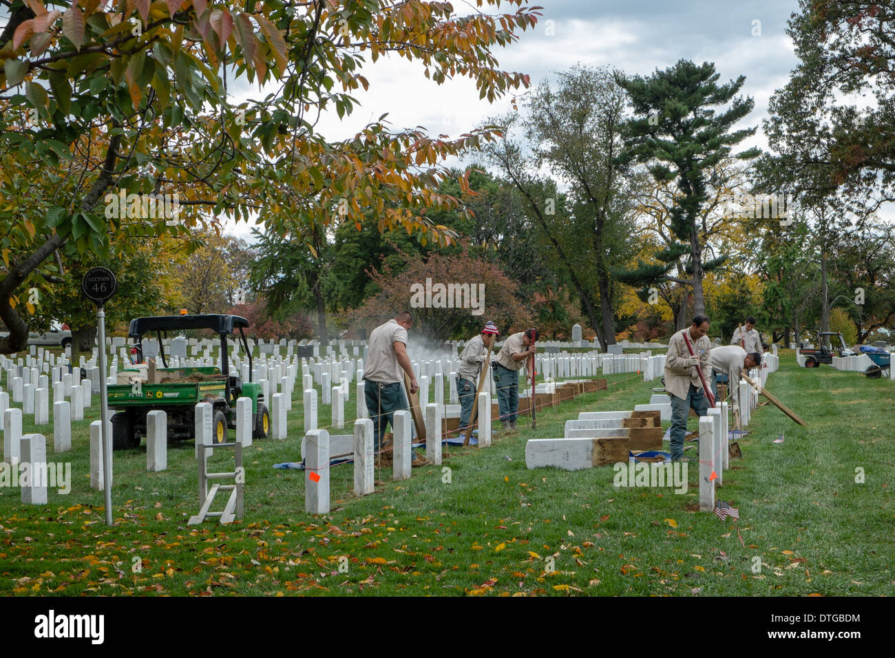 Employees of the Arlington National Cemetery, power wash and remove the headstones in order to level the ground. Stock Photo