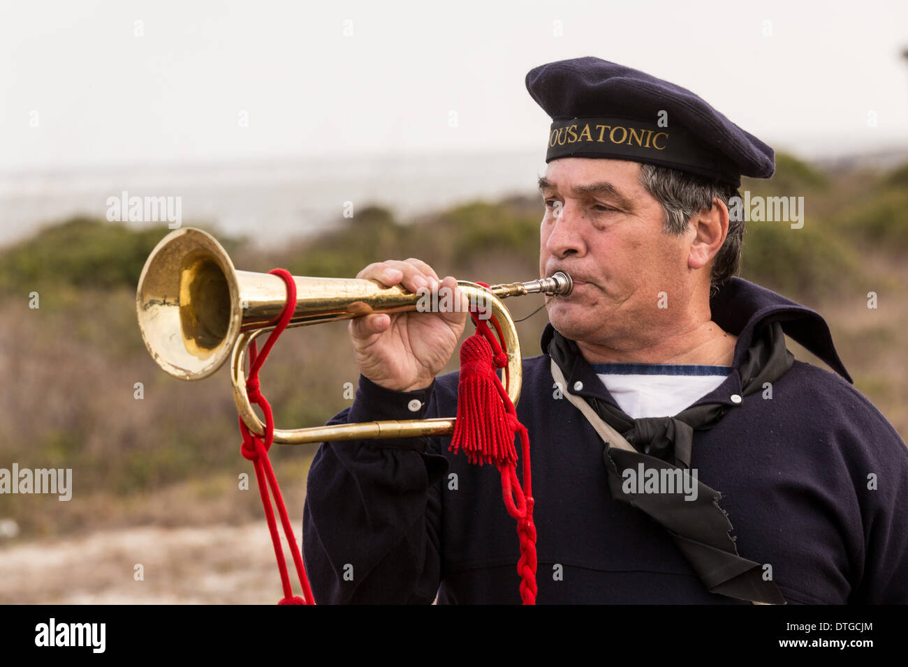 A lone bugler plays taps along Breach Inlet in honor of the sailors of the Union navy ship the USS Housatonic sunk by the Confederate submarine H.L. Hunley 150-year-ago during the Civil War February 17, 2014 on Sullivan's Island, SC. The Hunley was the first submarine to sink a ship in battle and then suffered an accident killing the crew. Stock Photo