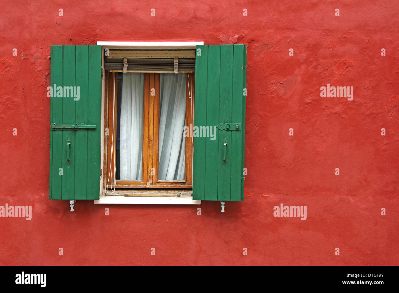 Old house red wall with green wooden window Stock Photo - Alamy