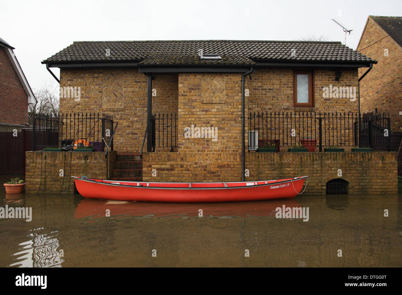 Ham Island, Thames Valley, UK Flood waters surround homes and gardens as a canoe is moored outside a house. Stock Photo