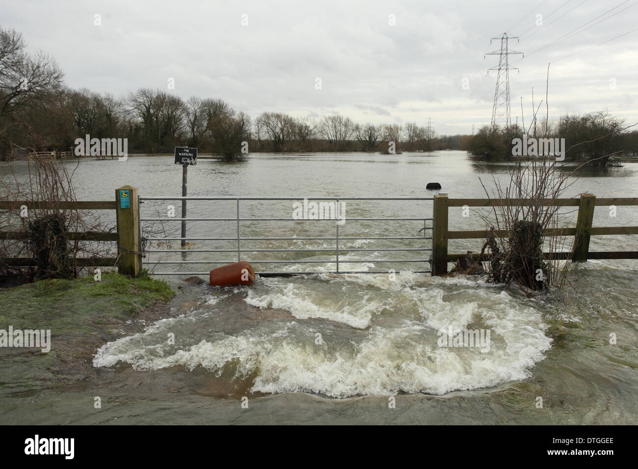 Chertsey, Thames Valley, UK. Flood waters drain from the road on to a flood plain bordering the Thames river. Stock Photo