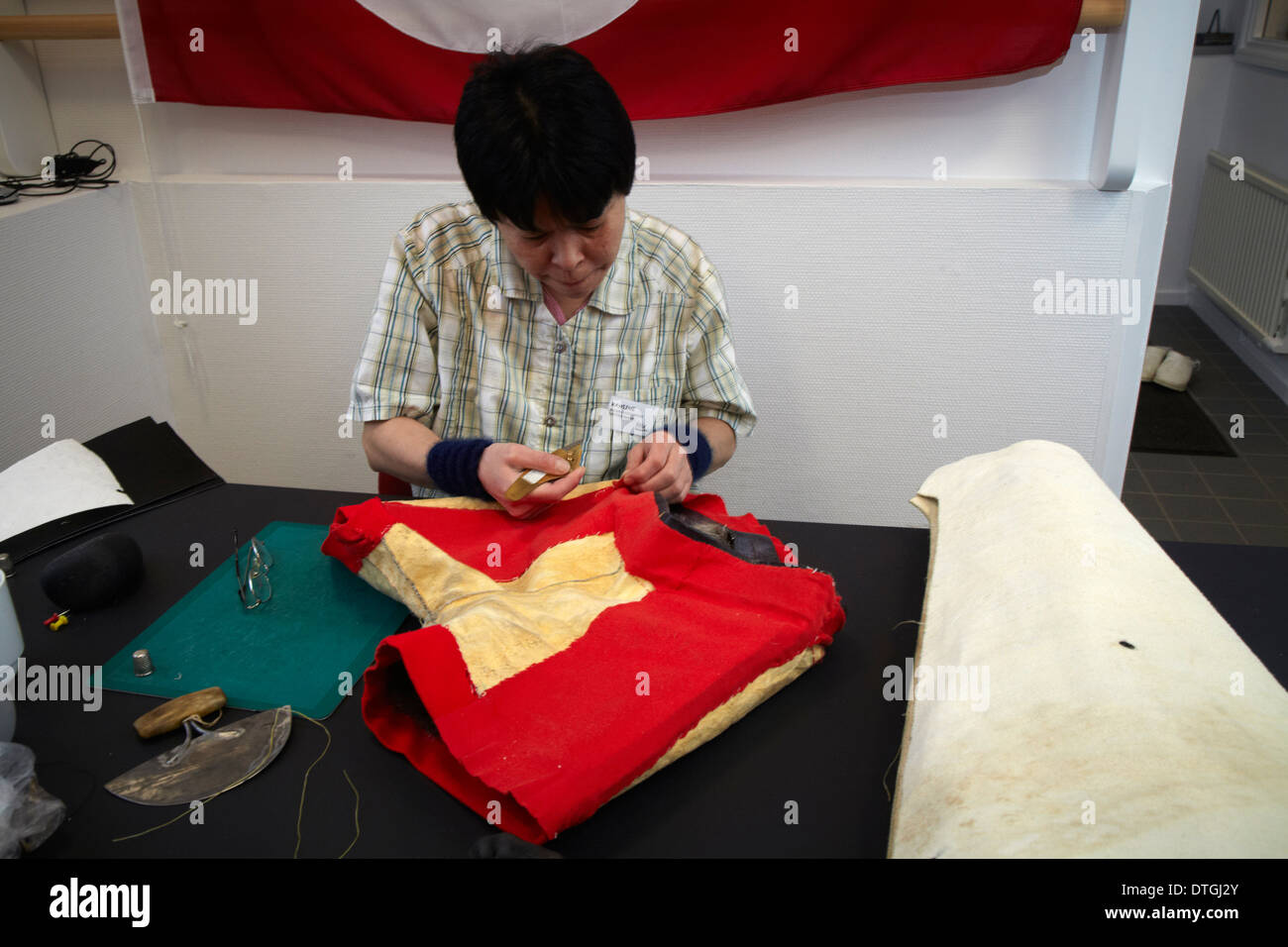 In a factory an Inuit woman makes a typical Greenlandic clothing from sealskin Stock Photo