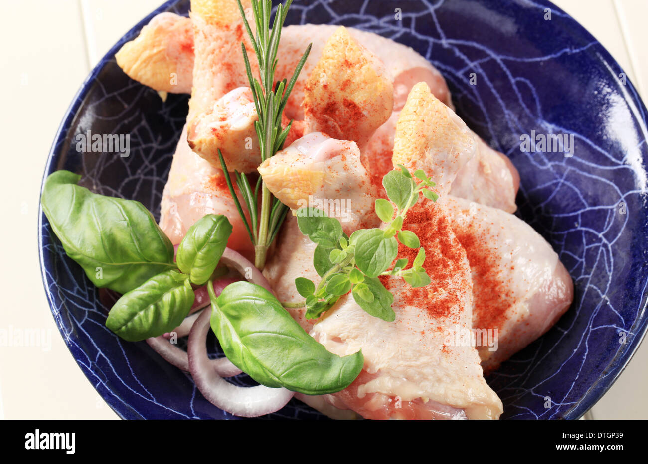 Raw chicken drumsticks seasoned with pepper Stock Photo