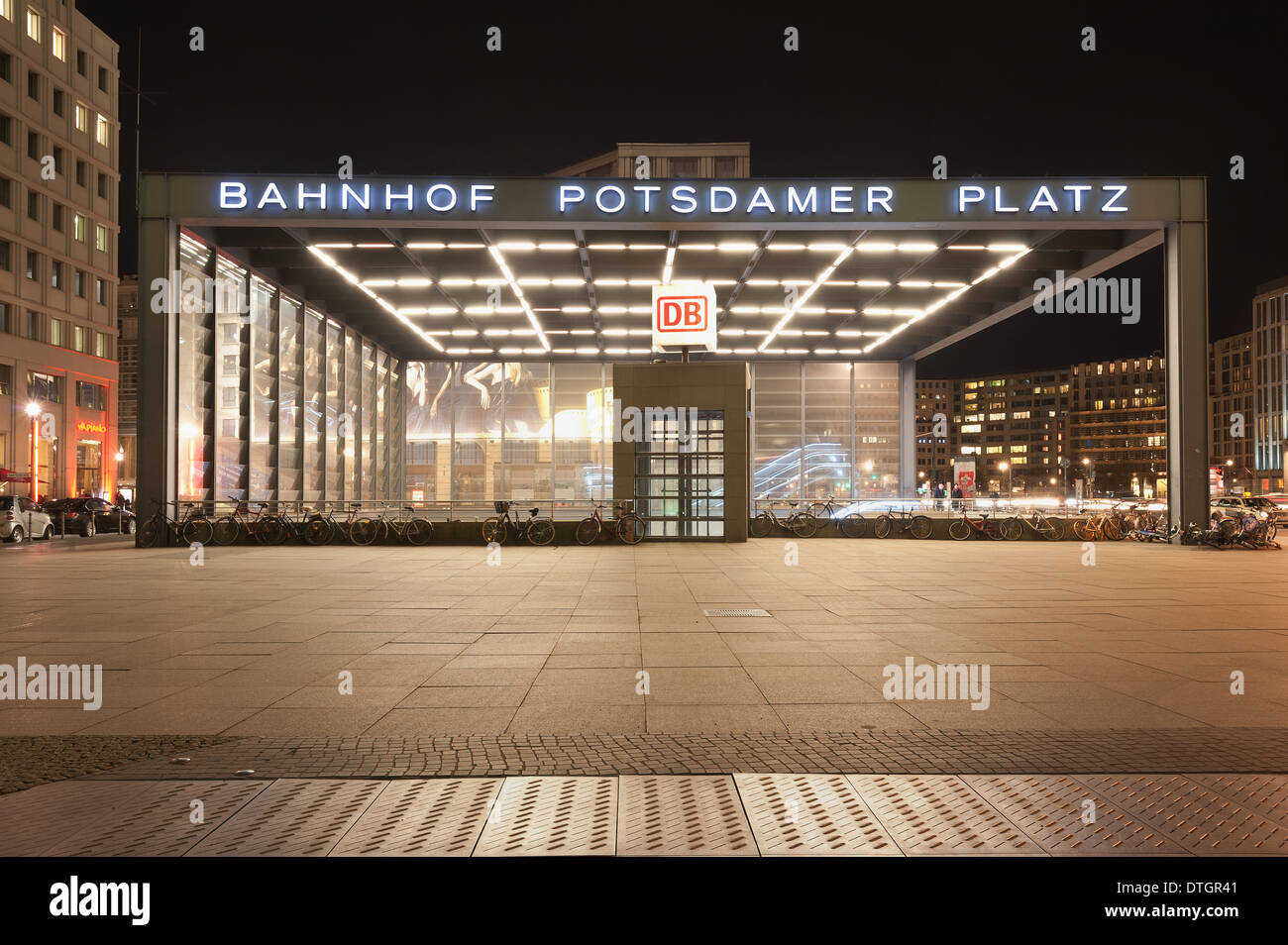 Potsdamer platz Bahnhof mainline station entrance on concourse to trains with rejuvenated city and modern skyline at night Stock Photo