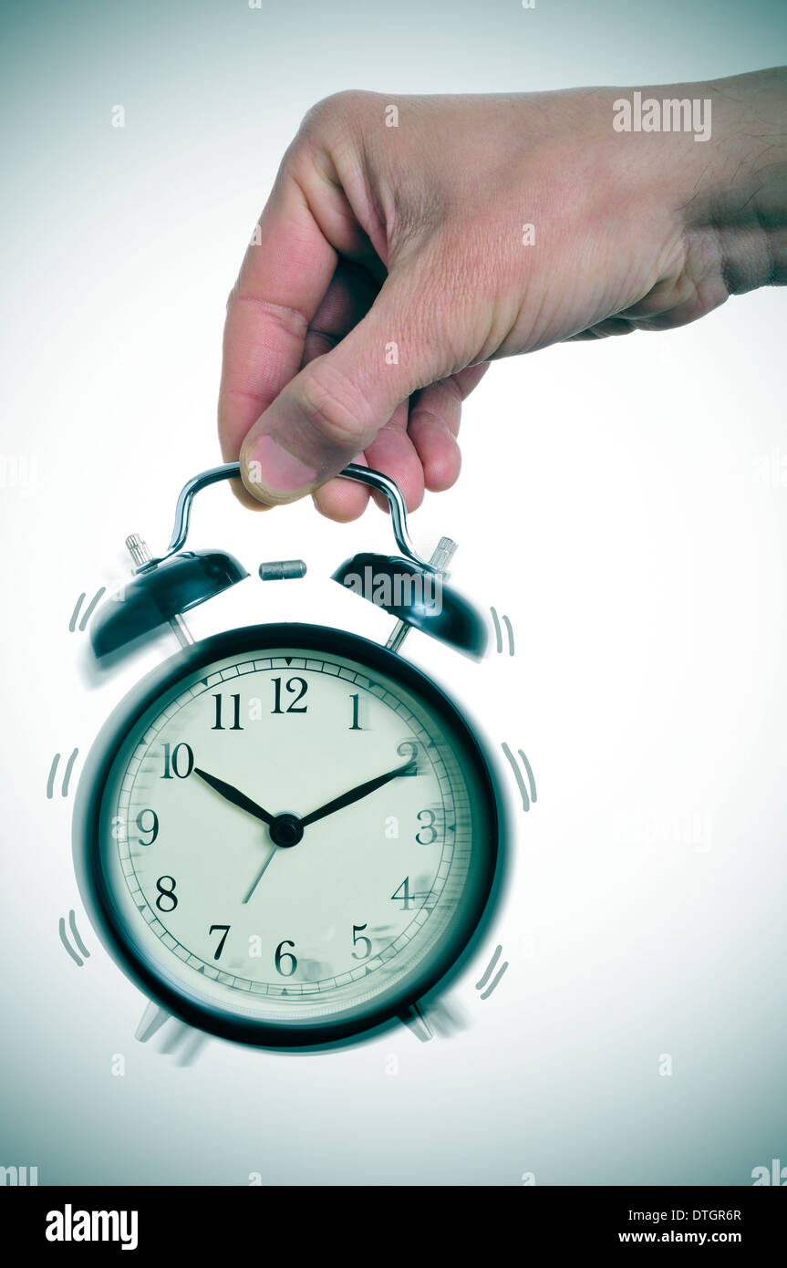 someone holding a typical mechanical alarm clock ringing Stock Photo