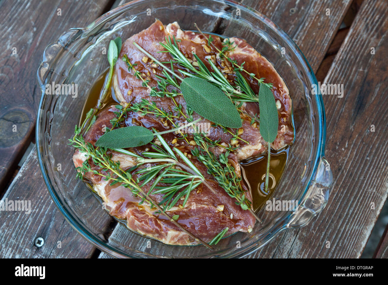 Pork neck steaks in marinade with herbs Stock Photo Alamy