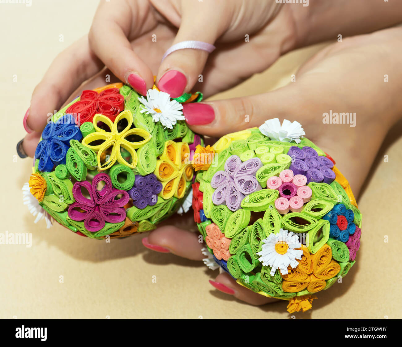 Woman holding in the hands two easter eggs made of colored paper. Stock Photo