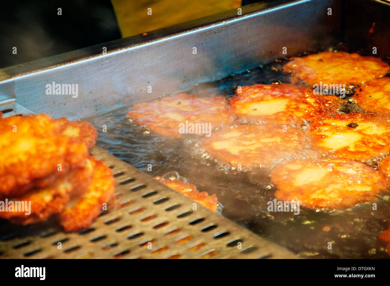 Potato fritters being cooked in a Vending Stall at a Christmas Market Stock Photo