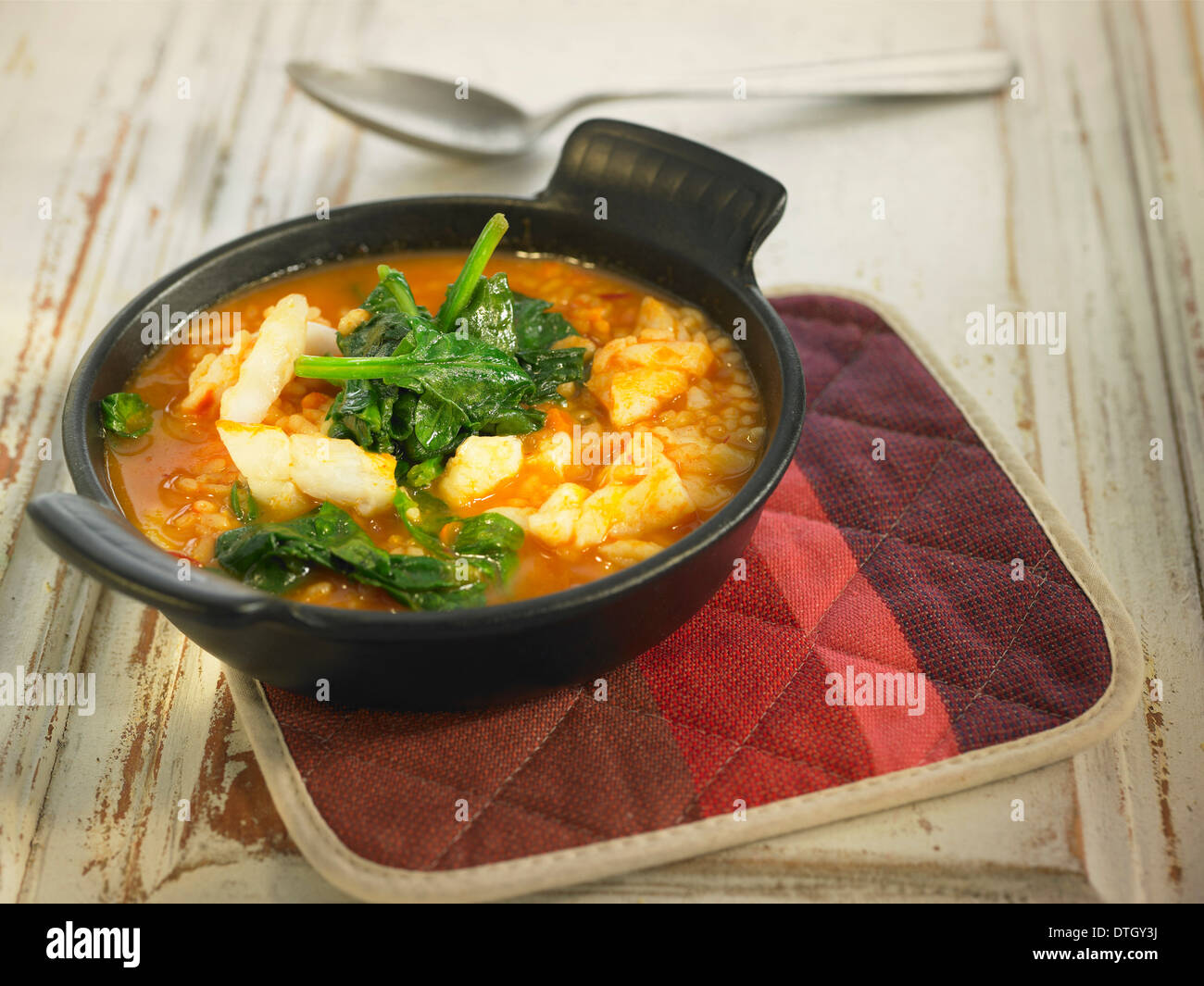 Rice with salt-cod and spinach in tomato sauce Stock Photo