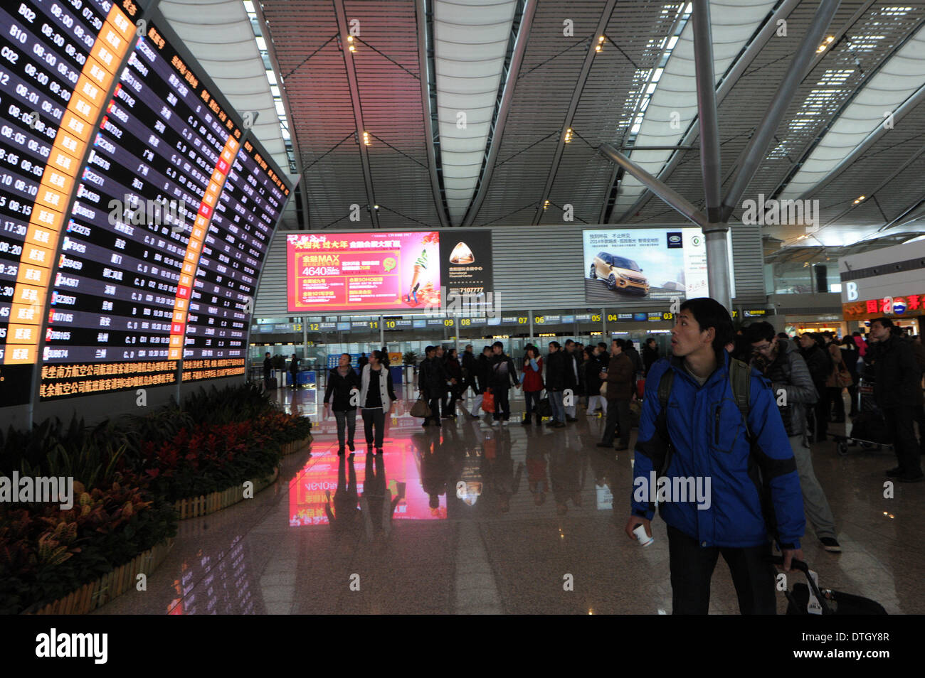 Guiyang, China's Guizhou Province. 18th Feb, 2013. Stranded passengers check on their flights information at Longdongbao International Airport in Guiyang, capital of southwest China's Guizhou Province, Feb. 18, 2013. Heavy snow led to temporary closure of the airport at 8 a.m. Tuesday for snow and ice removal. More than 90 flights were canceled and over 4,800 passengers were affected before the airport was reopened at noon. Credit:  Tao Liang/Xinhua/Alamy Live News Stock Photo