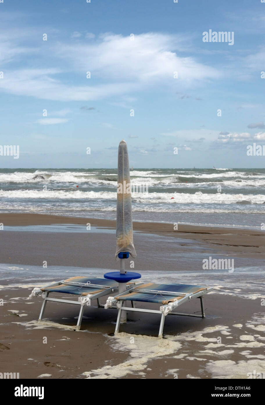lonely canvas chairs at the beach with rough sea in Southern Italy Stock Photo