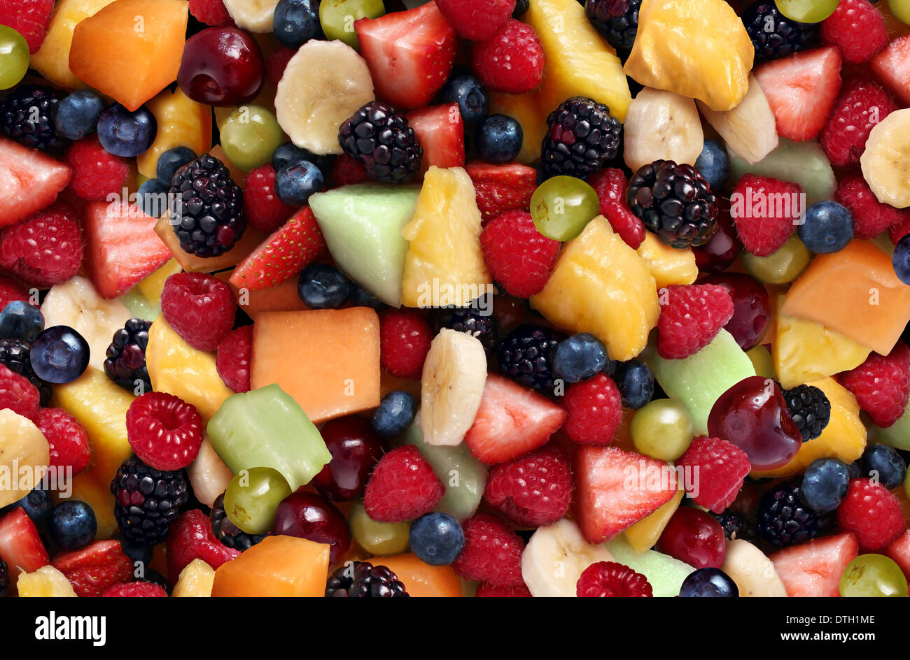 Fruit salad background featuring fresh berries and cut fruits as as blueberry blackberry green
