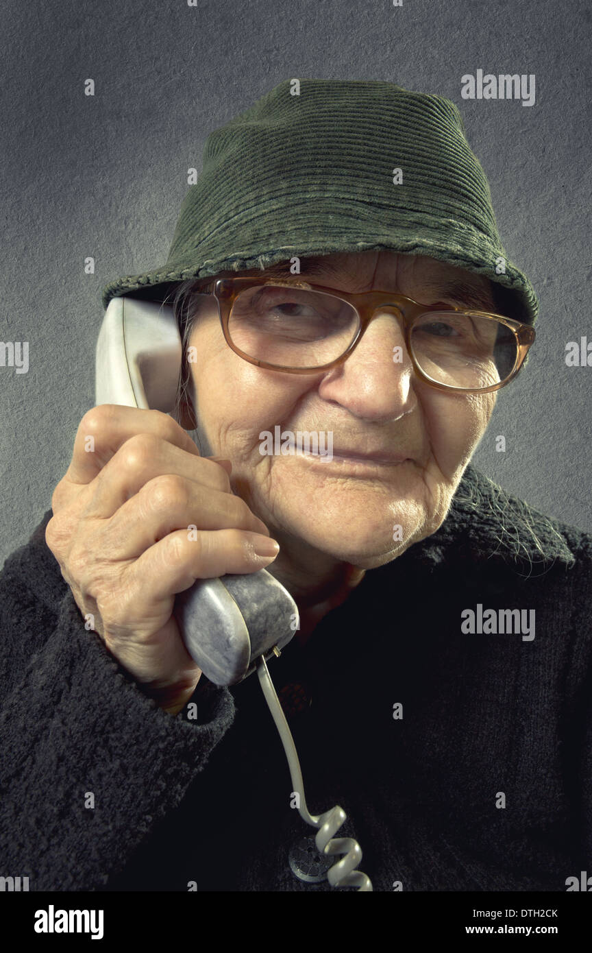 Positive senior woman talking on the phone on a vintage background. Stock Photo