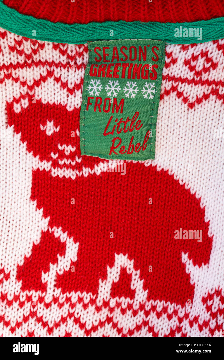 Season's greetings from Little Rebel label in child's winter Christmas jumper clothing Stock Photo