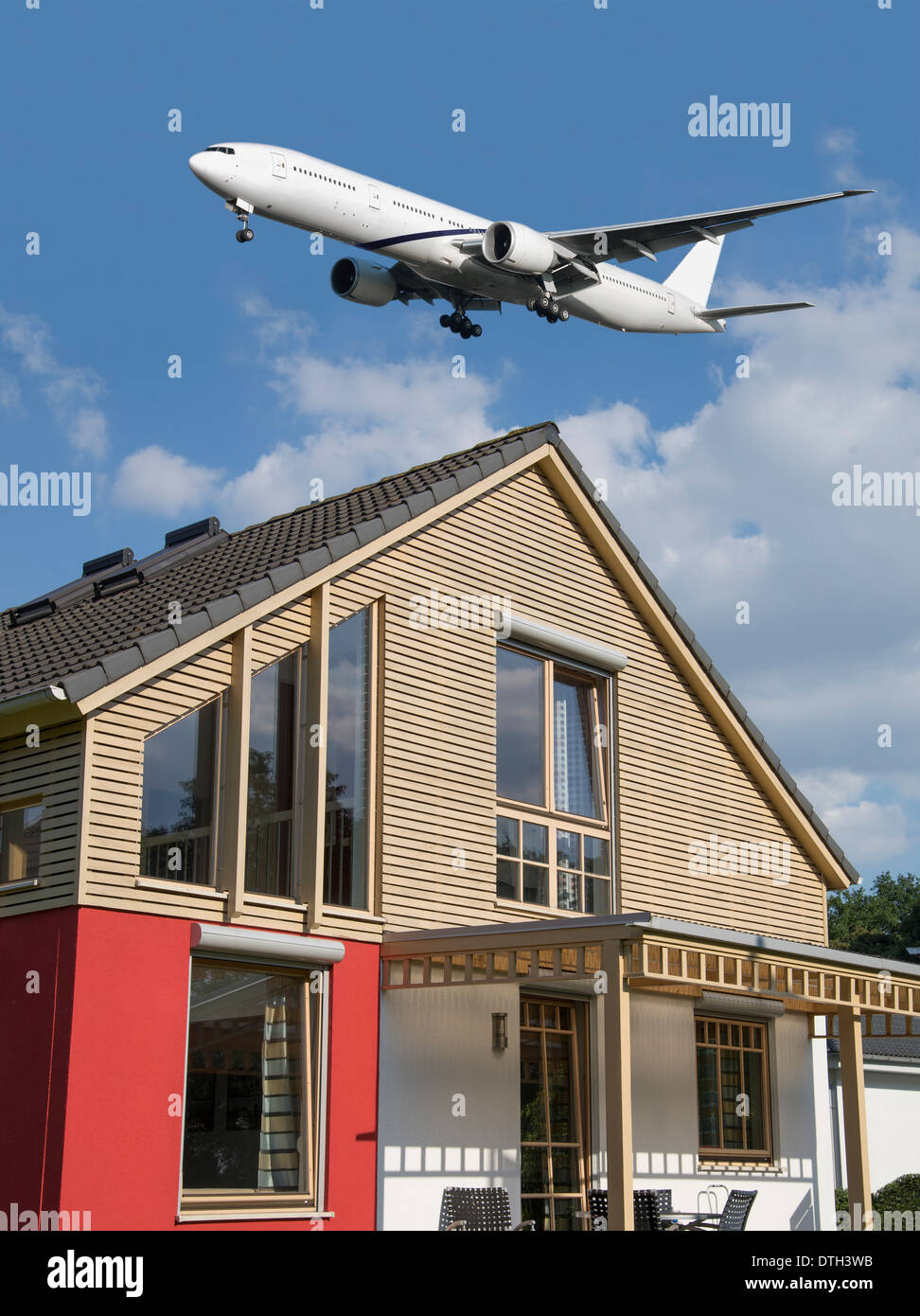 Transport airplane landing over a residential building. Stock Photo