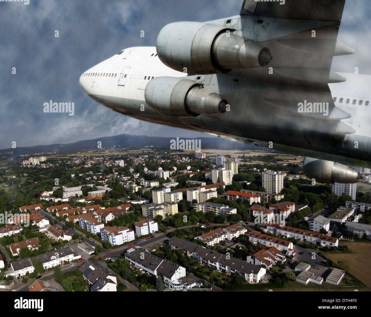 An airliner flies over a small town Stock Photo