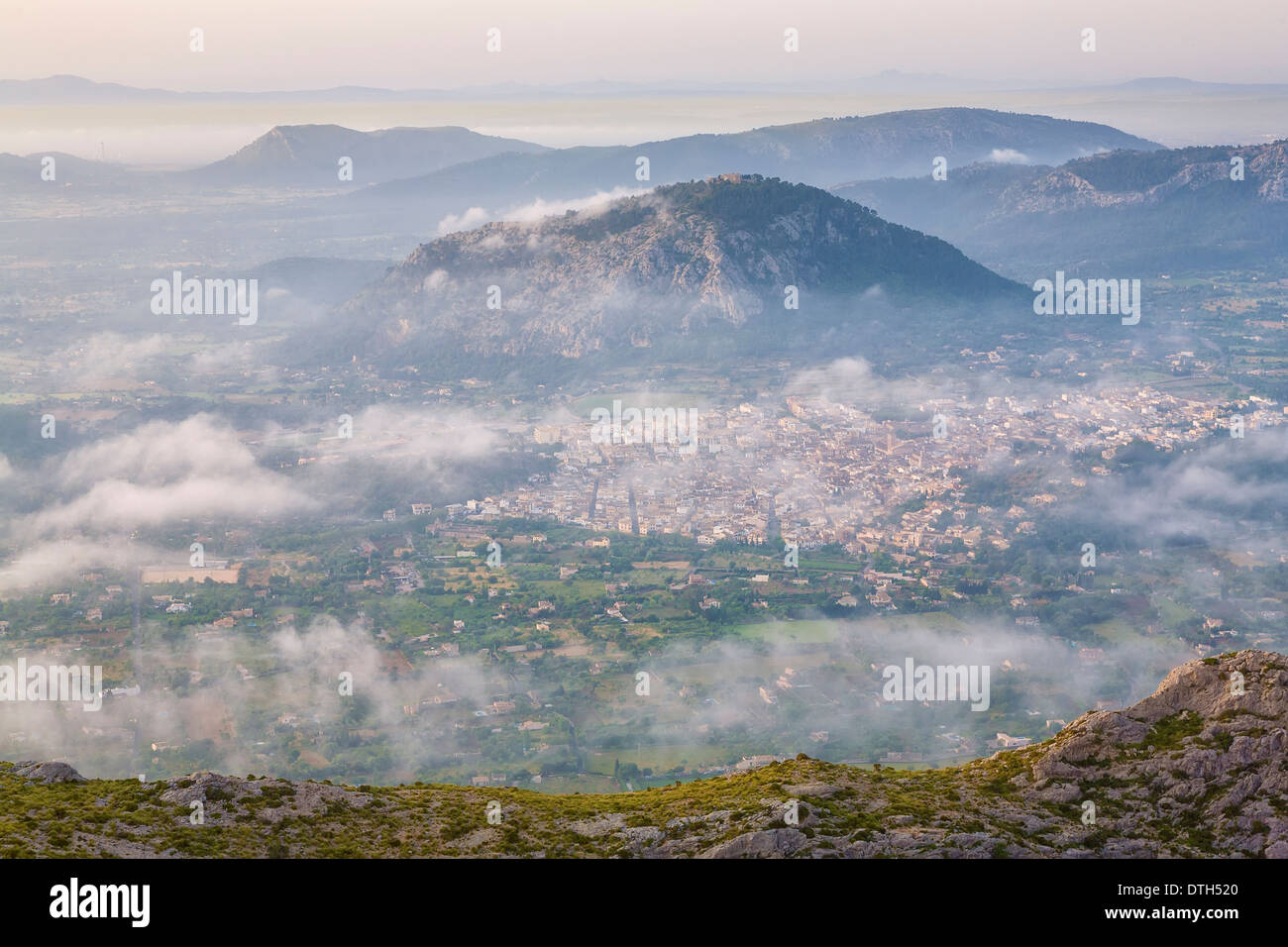 Aerial view of Pollensa town and Puig de Maria hill in a misty Spring early morning. Majorca, Balearic islands, Spain Stock Photo