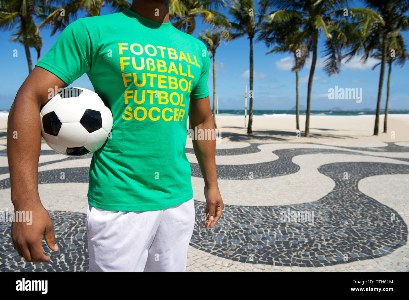 Brazilian soccer player wearing international football shirt holding soccer ball at Copacabana Beach Rio de Janeiro Stock Photo