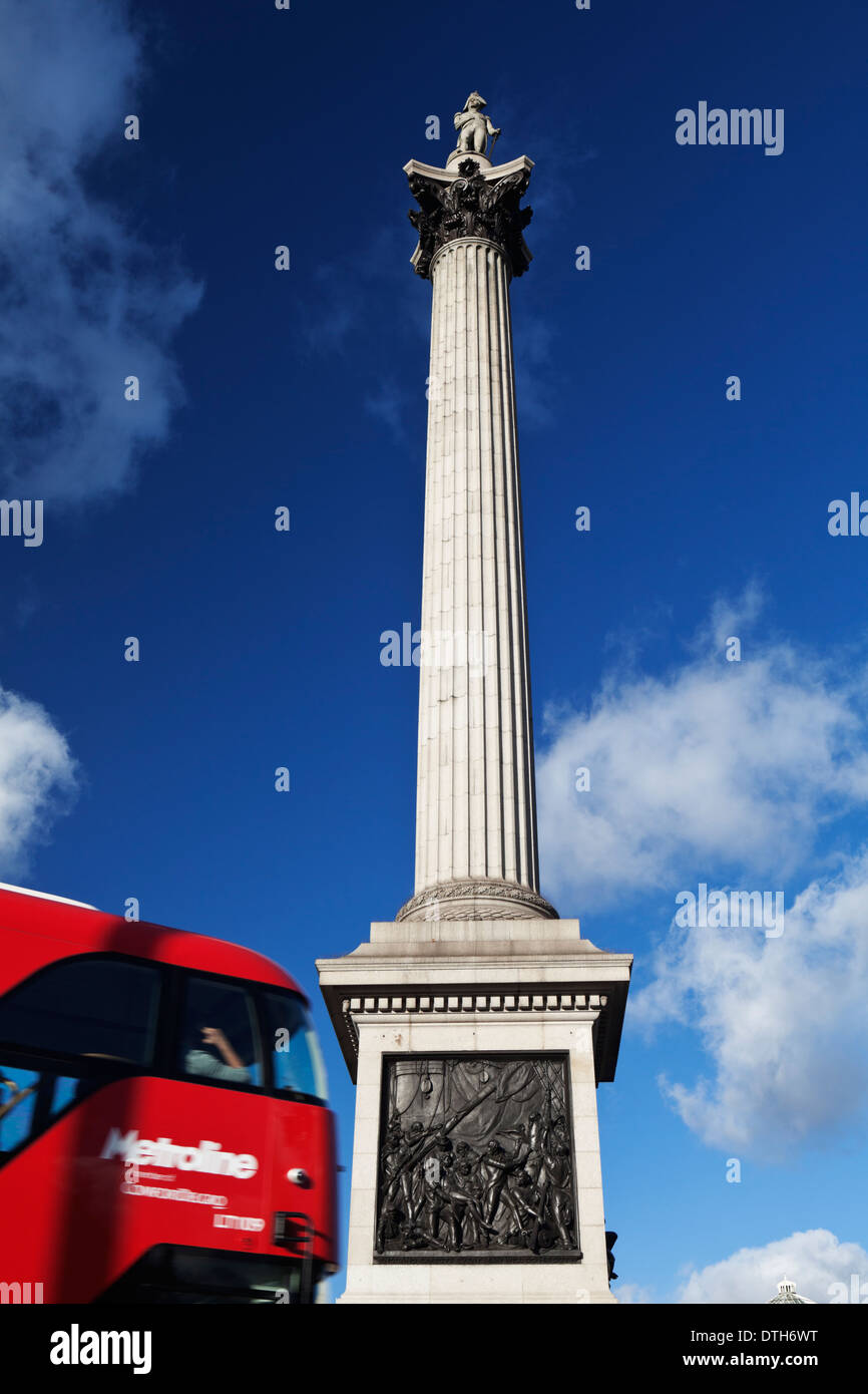 A red London bus passes Nelson's Column. Stock Photo