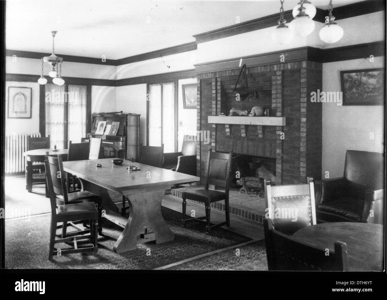 This historical image shows an interior room featuring a piano and ...