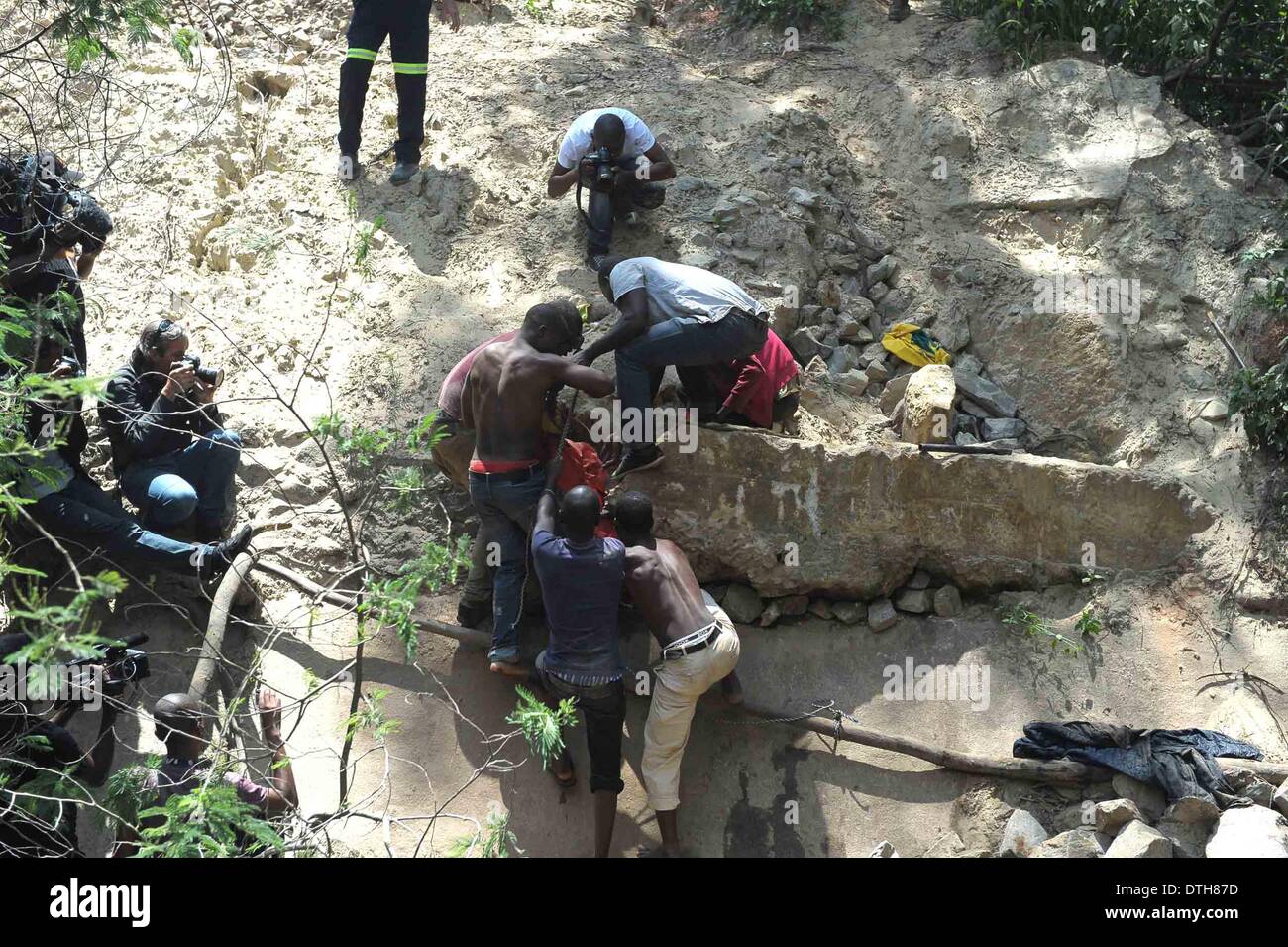 Johannesburg, South Africa. 18th Feb, 2014. People carry the body of an illegal miner from an illegal gold mine in Benoni, outside Johannesburg, South Africa, Feb. 18, 2014. An illegal miner's body was discovered at an abandoned gold mine in Benoni where an accident happened a week ago. © Li Qihua/Xinhua/Alamy Live News Stock Photo