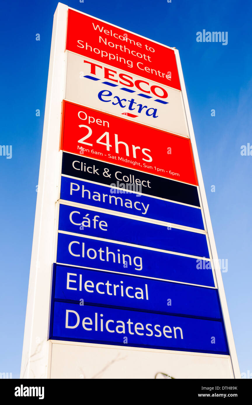 Tesco Extra 24 hours sign with pharmacy, cafe (spelled incorrectly), clothing, electrical and delicatessen Stock Photo