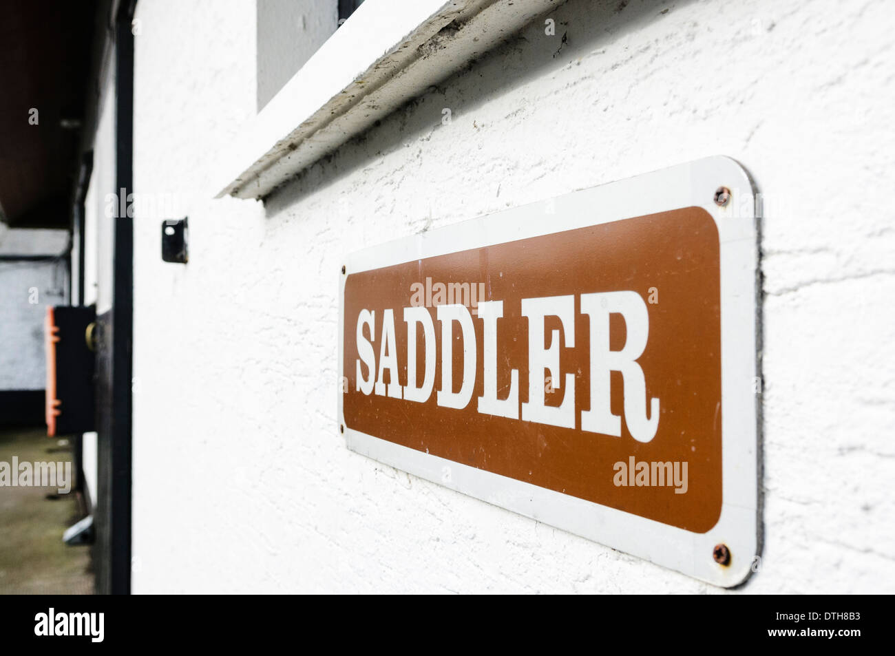Sign for a saddler at a stable yard Stock Photo