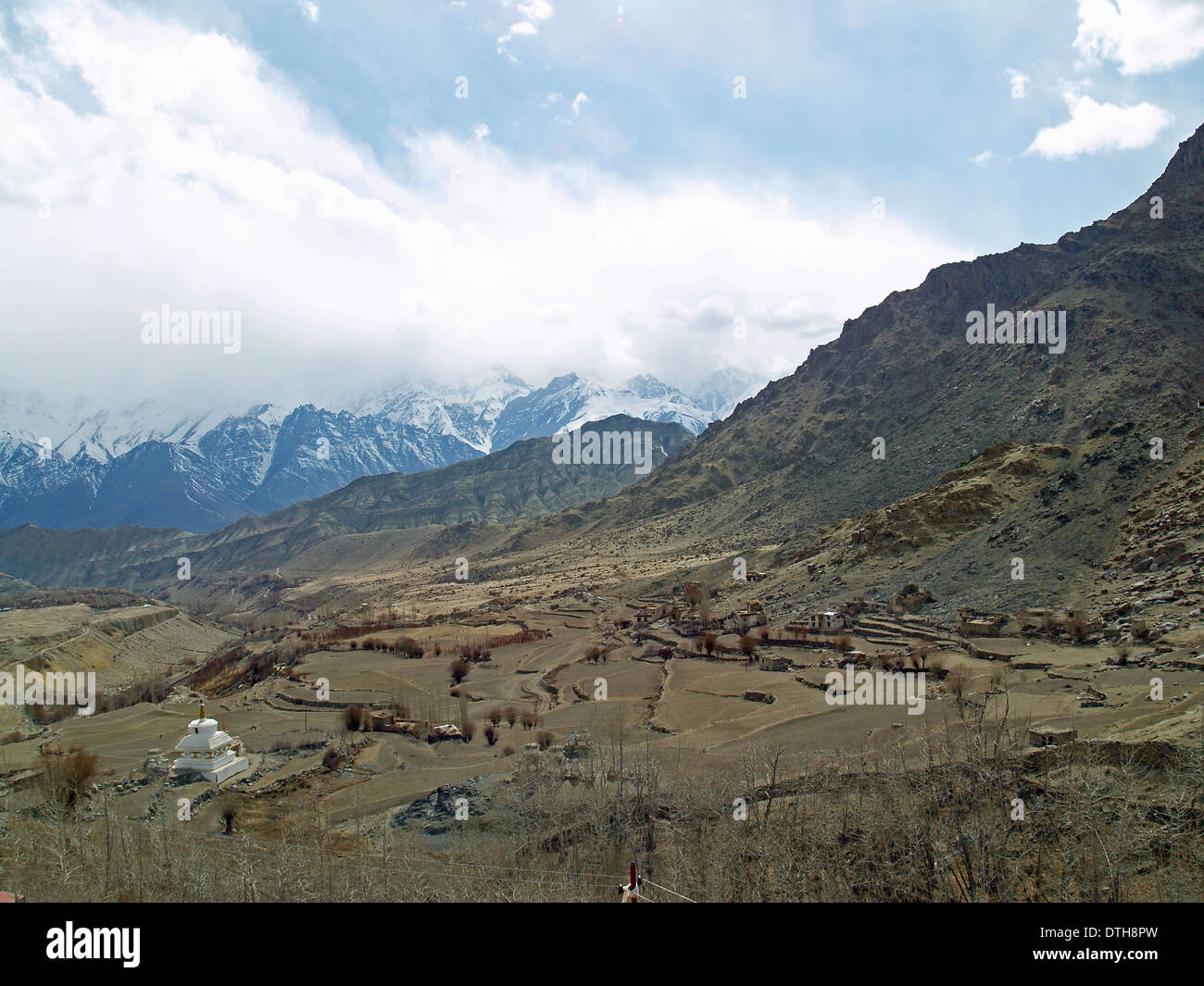 A white stupa sits beneath the Himalayan Mountains in Ladakh,India ...