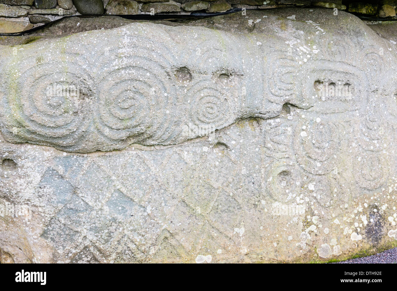 Spiral and lozenge carvings on one of the kerb stones at Newgrange chambered passage tomb Stock Photo