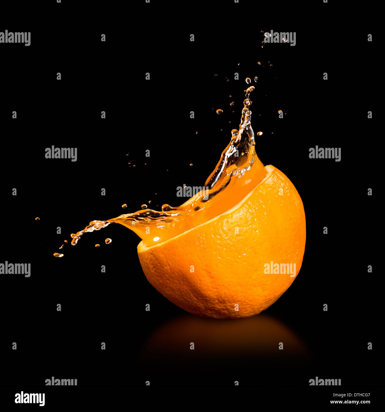 Orange juice splashing isolated on black Stock Photo