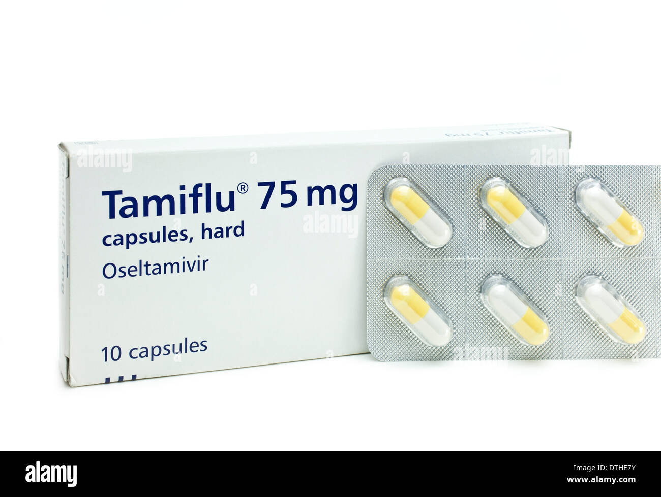 Yellow and white Tamiflu capsules in a blister pack next to a box of Tamiflu on a white background Stock Photo